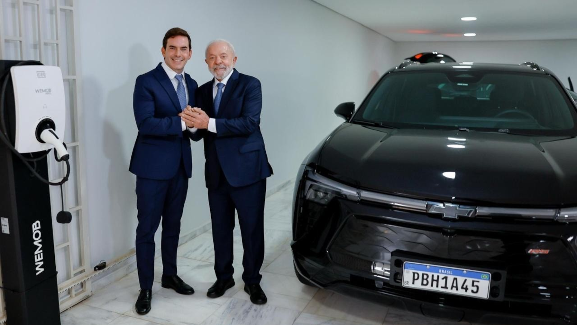 Lula posa com o executivo Fábio Rua, vice-presidente da General Motors América do Sul, e um carro Chevrolet Blazer EV, e um carregador WEG