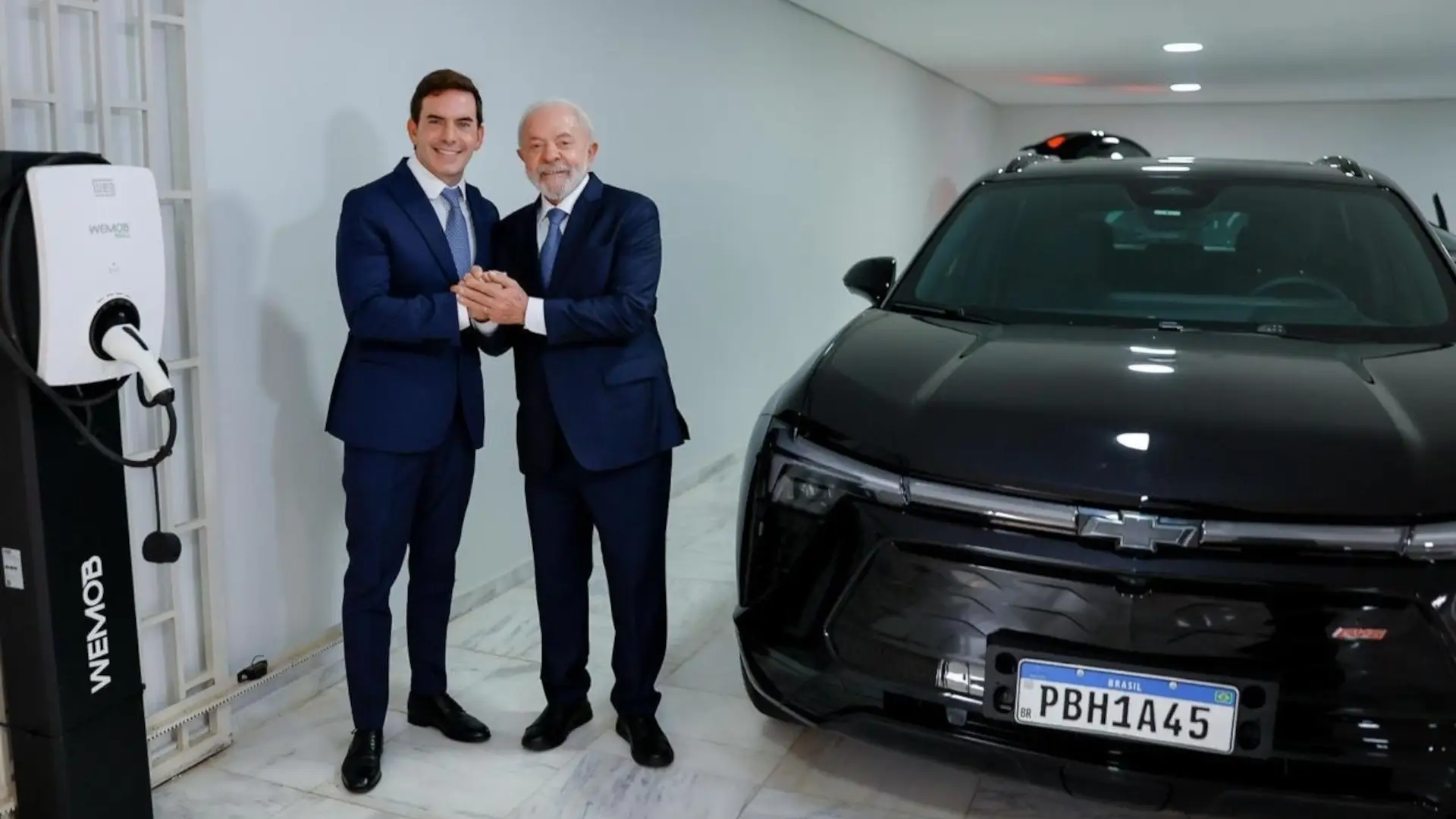 Lula posa com o executivo Fábio Rua, vice-presidente da General Motors América do Sul, e um carro Chevrolet Blazer EV, e um carregador WEG