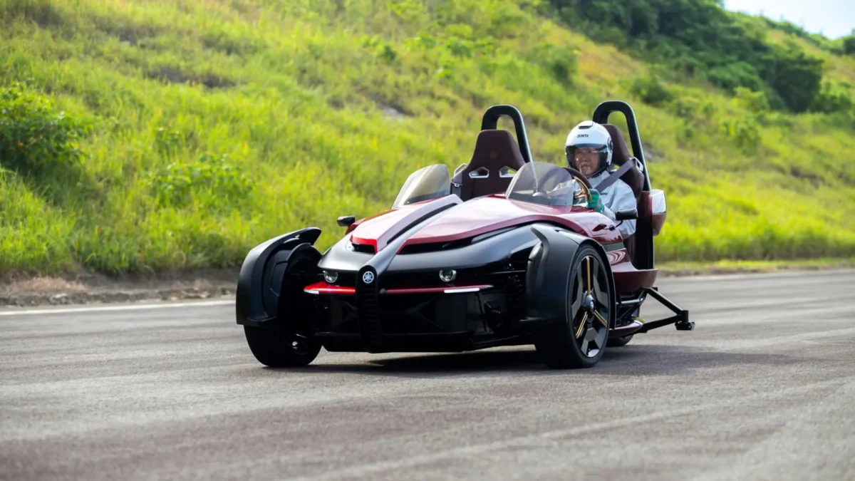 Foto do triciclo elétrico Yamaha Tricera Proto, com um piloto, na pista