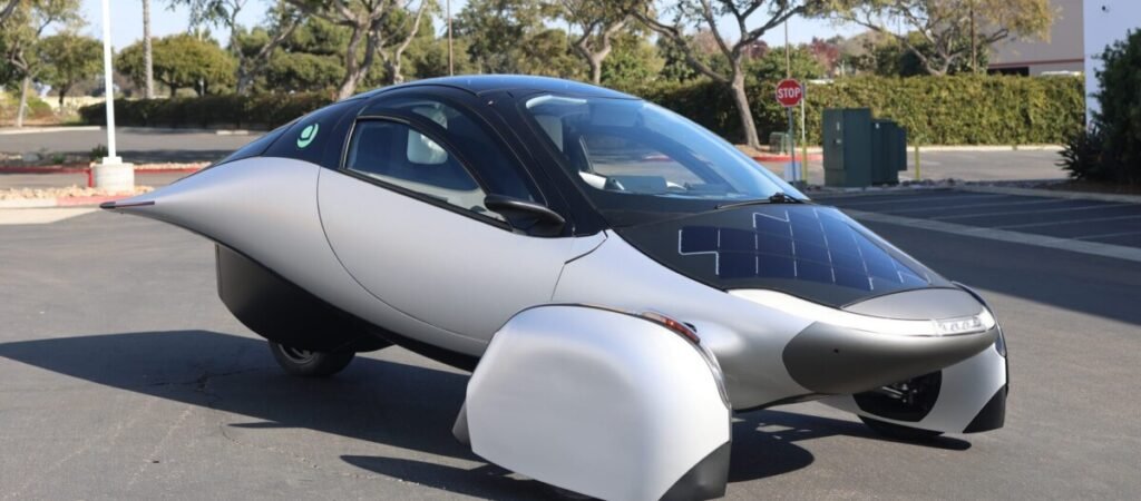 Foto do triciclo elétrico solar Aptera parado num pátio