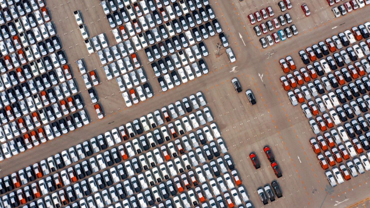 Visão aérea de carros no pátio de uma montadora