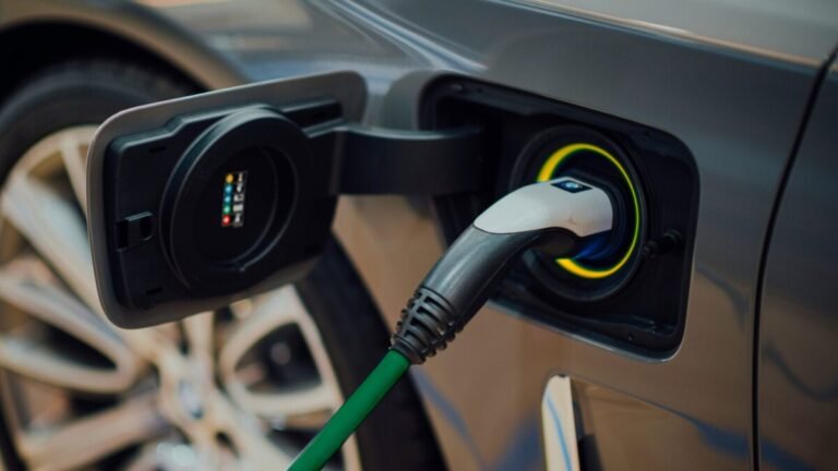 Plug elétrico no carro, com a corda verde e receptor amarelo