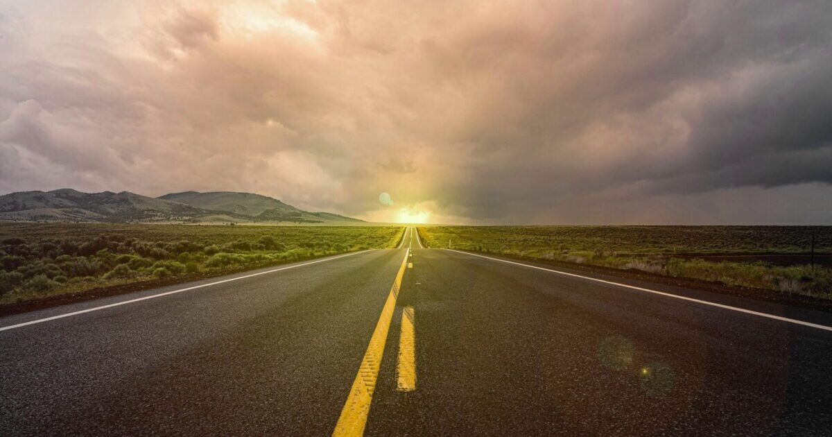Foto de uma longa estrada sumindo no horizonte