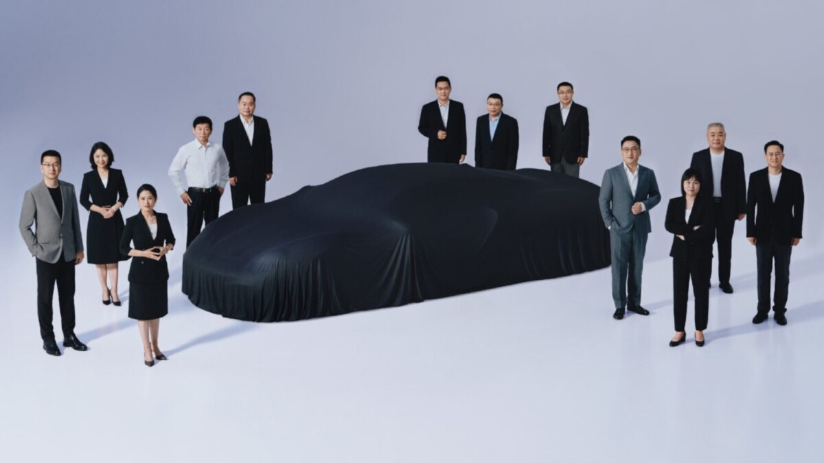 Foto promocional da Great Wall Motors mostrando um carro esportivo coberto e cercado por funcionários da marca