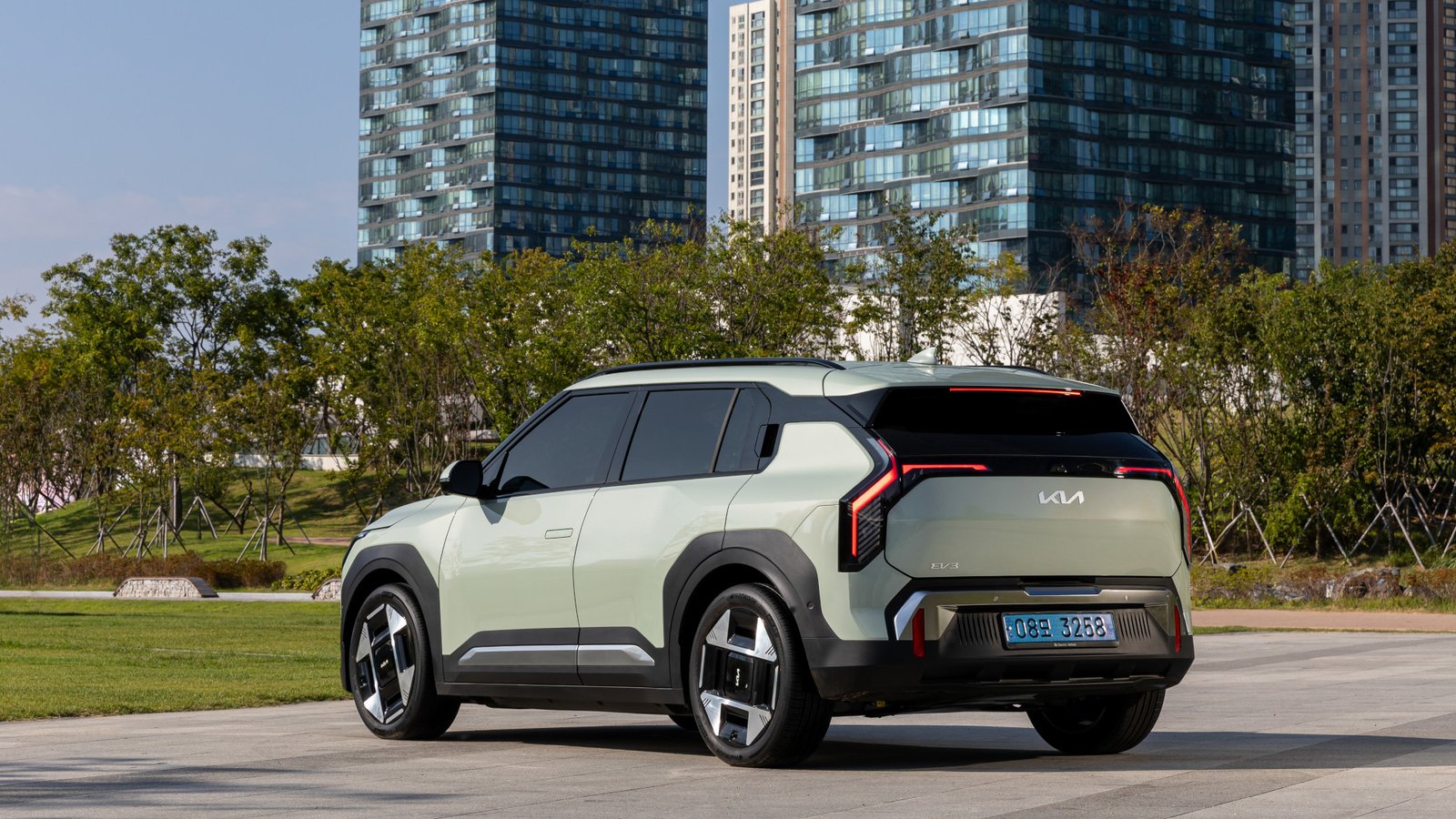 Foto promocional do carro elétrico Kia EV3, estacionado, traseira