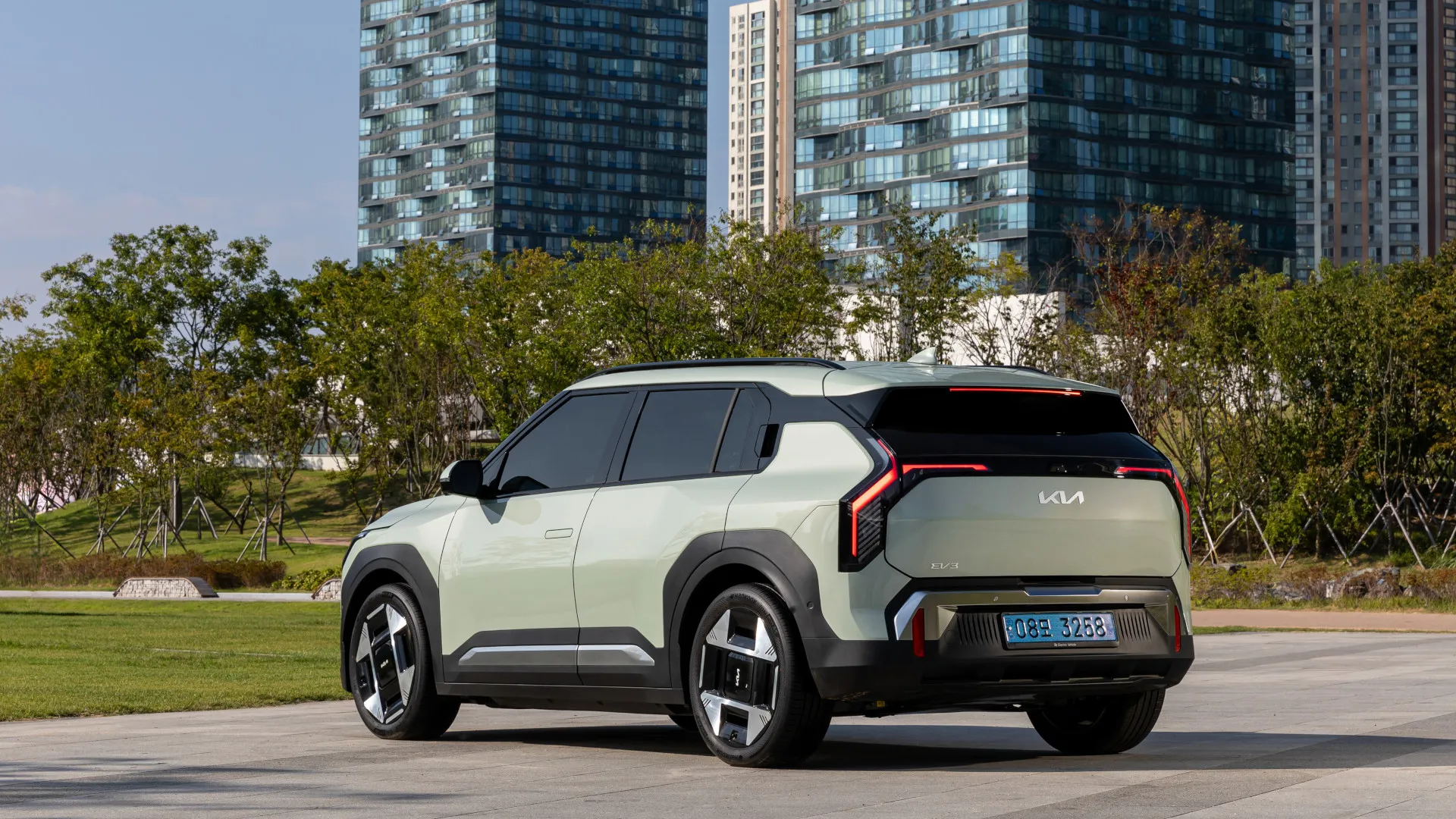 Foto promocional do carro elétrico Kia EV3, estacionado, traseira