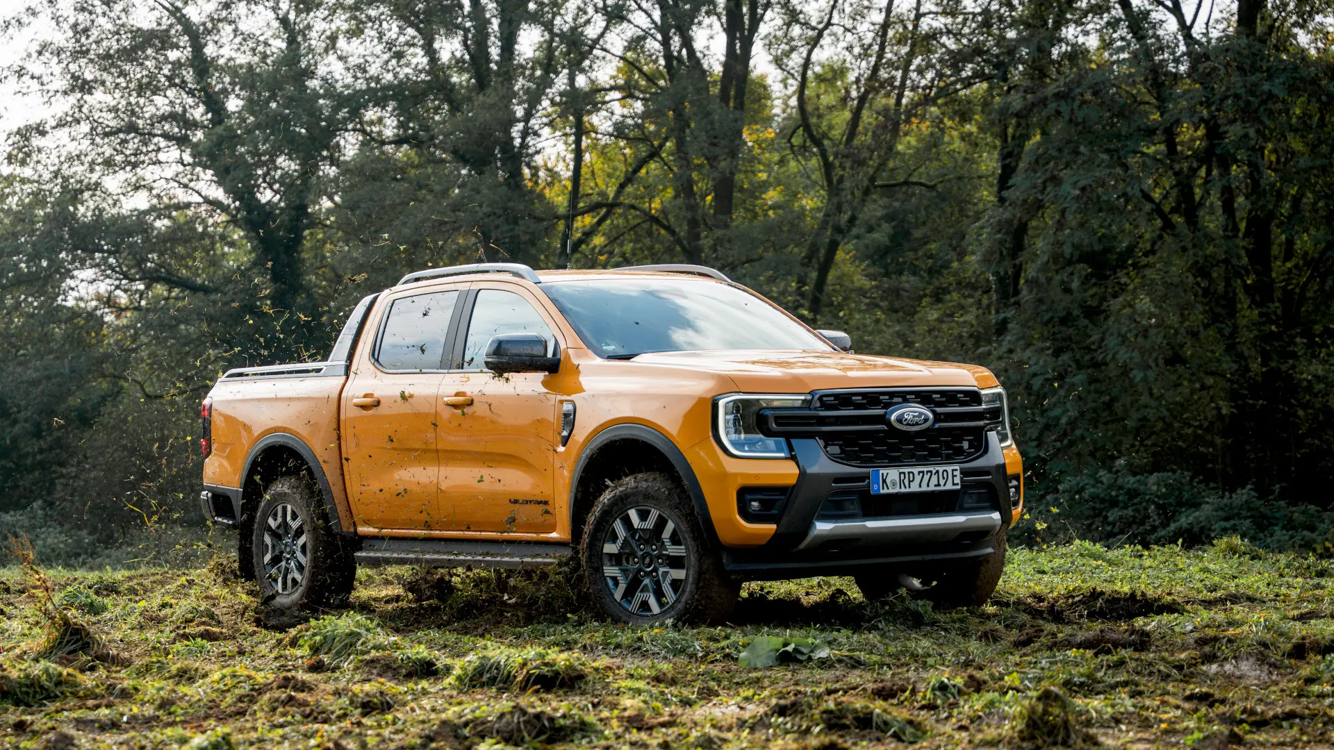 Foto da Ford Ranger híbrida plug-in, fora da estrada, enlameada