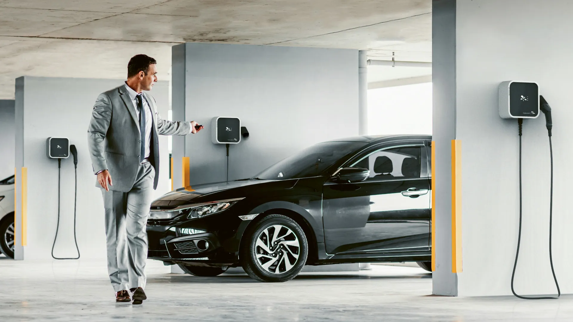 Homem numa garagem de condomínio com wallboxes