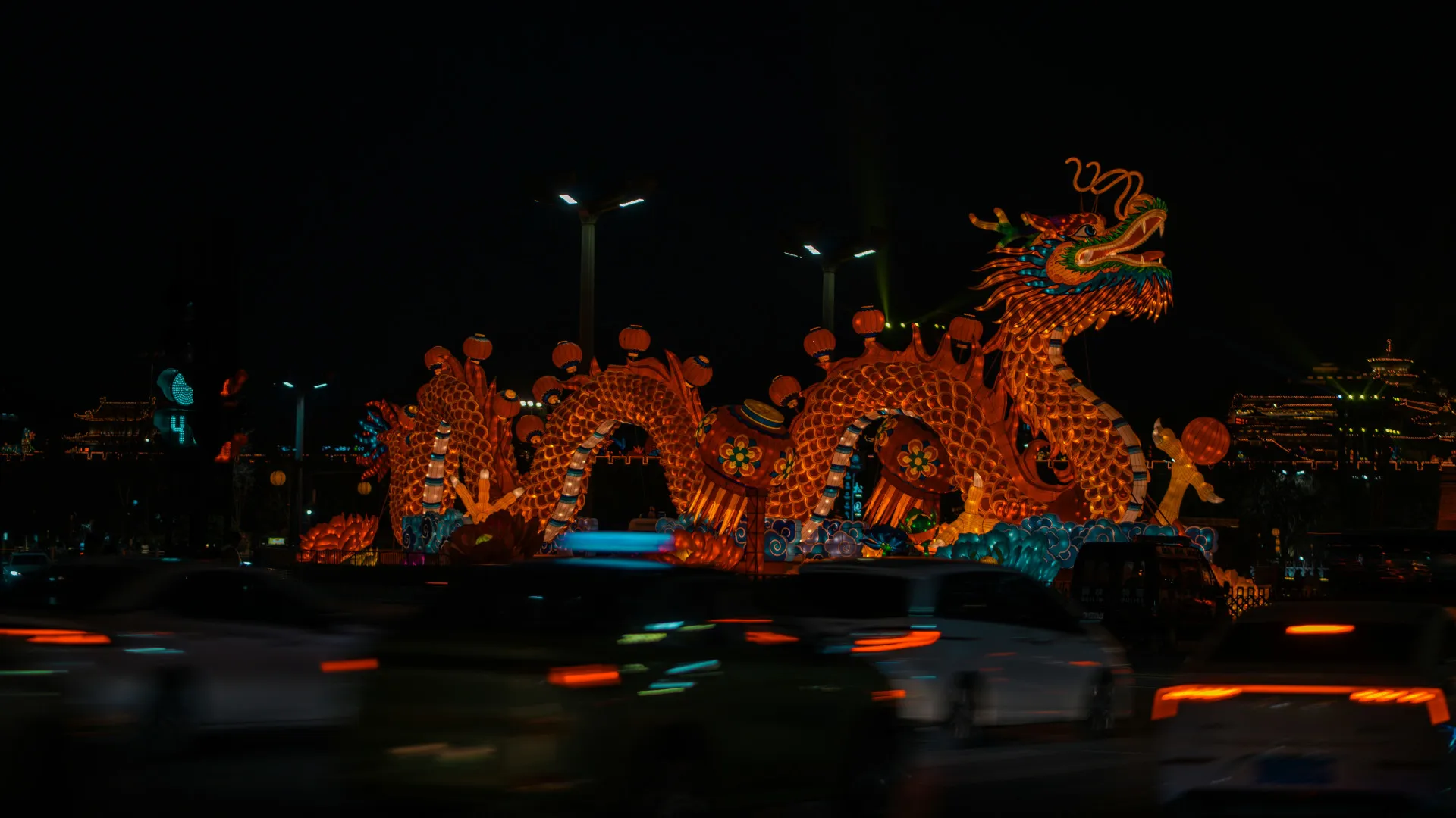 Tráfego passando em frente a estátua de dragão na China, em Xian, Shaanshi