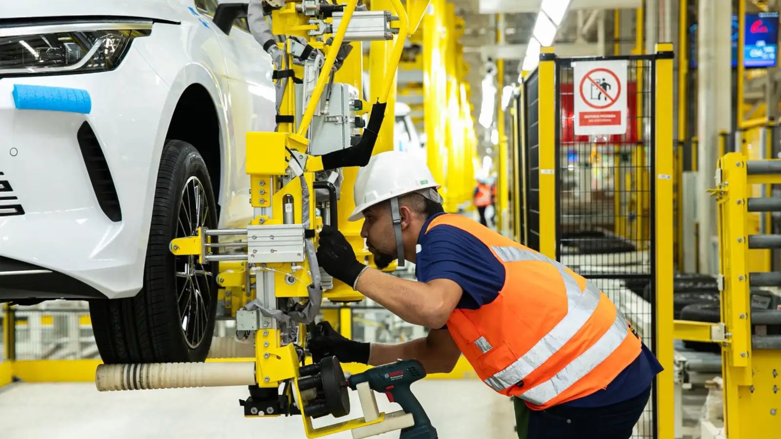 Foto de trabalhador montando um BYD Dolphin Mini na fábrica da BYD em Camaçari, Bahia