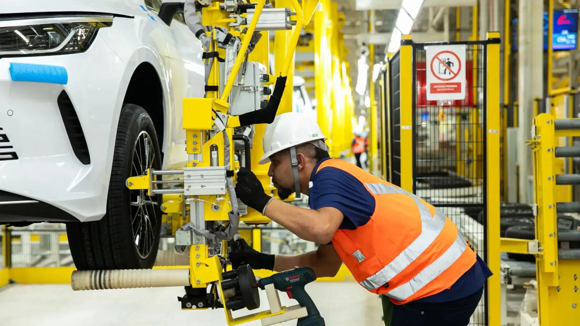 Foto de trabalhador montando um BYD Dolphin Mini na fábrica da BYD em Camaçari, Bahia