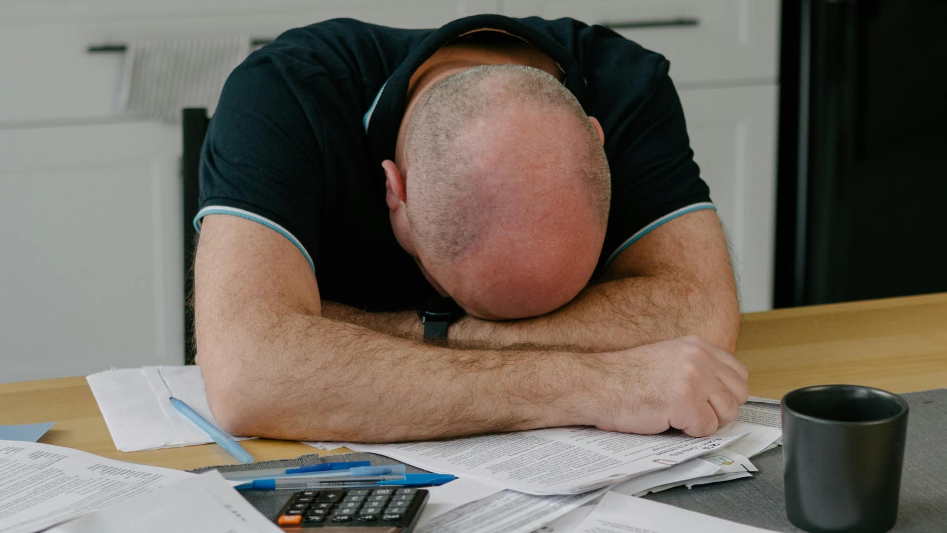 Homem pagando impostos, prostrado de frustração