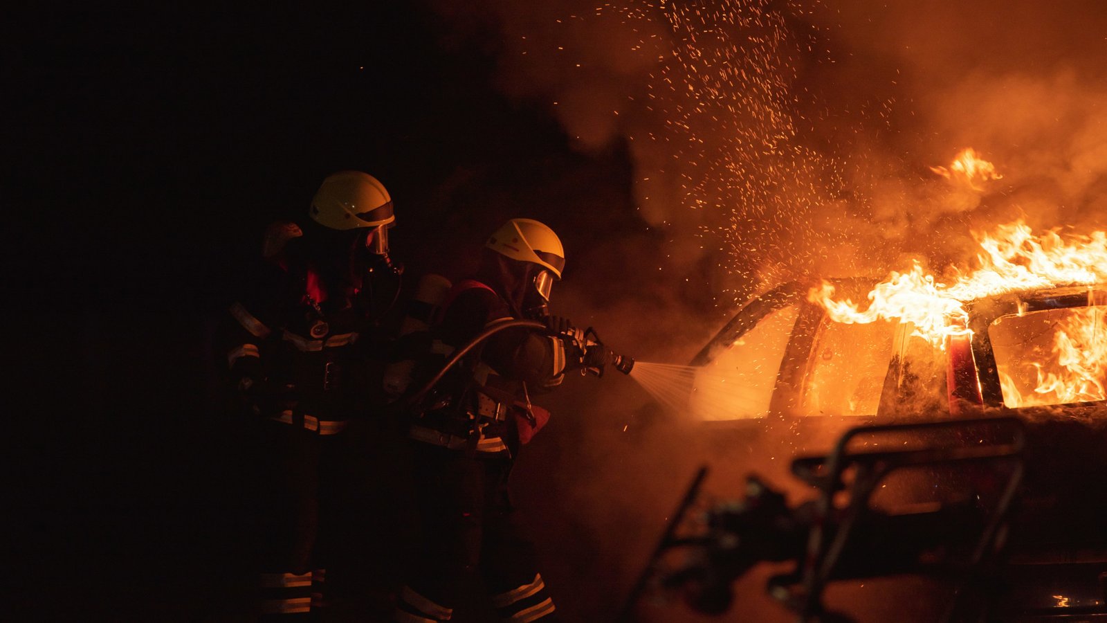 Bombeiros combatendo um incêndio veicular