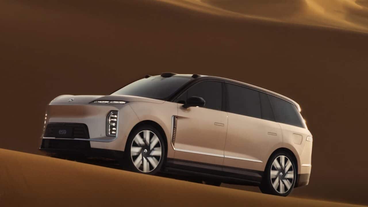SUV elétrico de luxo NIO ES9 em tom bege claro atravessando dunas no deserto