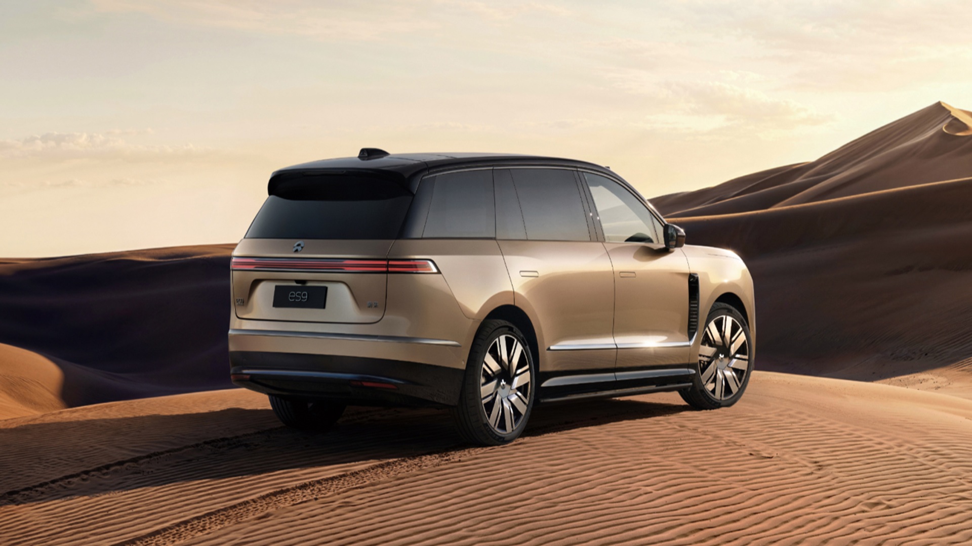 Traseira do SUV elétrico de luxo NIO ES9 em tom bege claro atravessando dunas no deserto