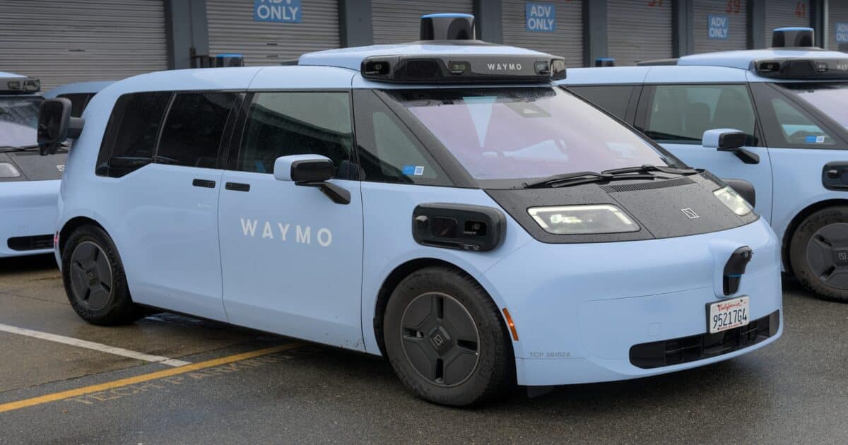 Robotáxi Ojai da Waymo, desenvolvido em parceria com a chinesa Zeekr, estacionado ao lado de outras unidades da frota. O veículo elétrico azul-claro conta com sensores, câmeras e sistema lidar no teto para operação autônoma nos Estados Unidos