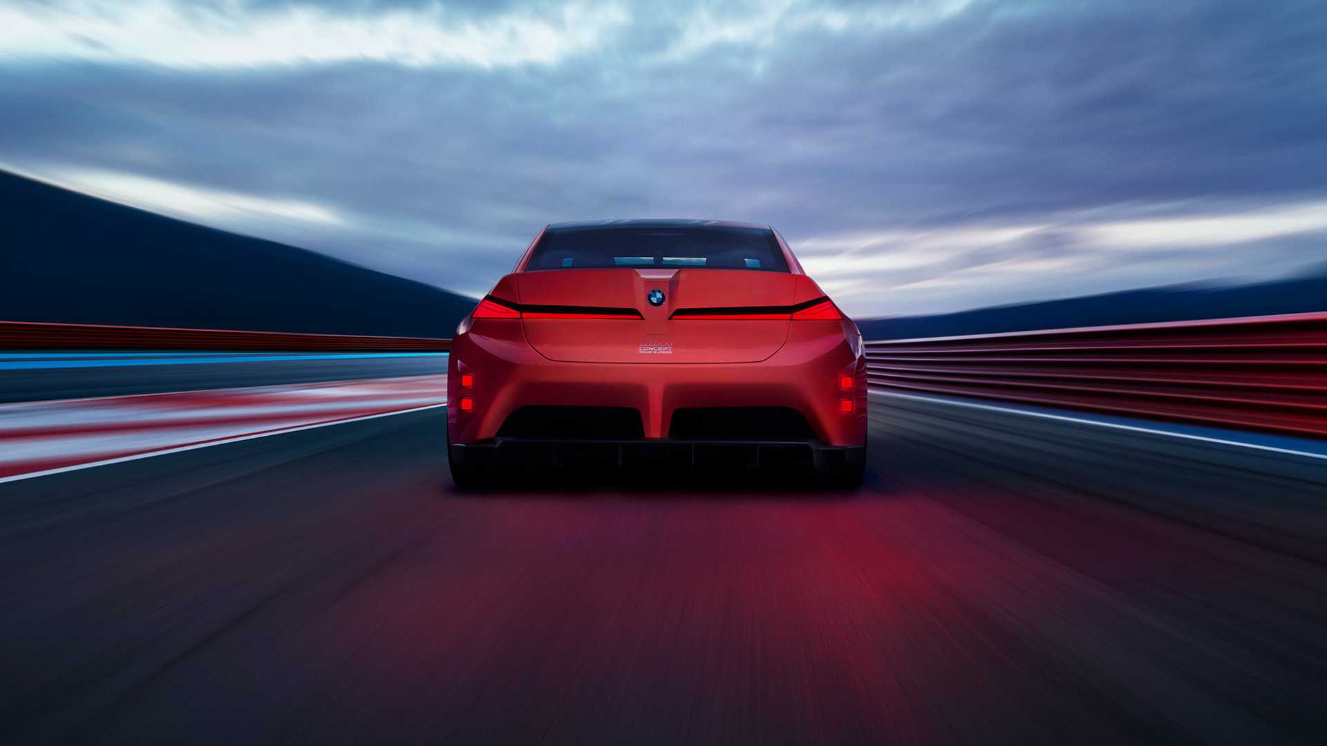 BMW M Neue Klasse vermelho em vista traseira em alta velocidade em circuito de corrida ao entardecer