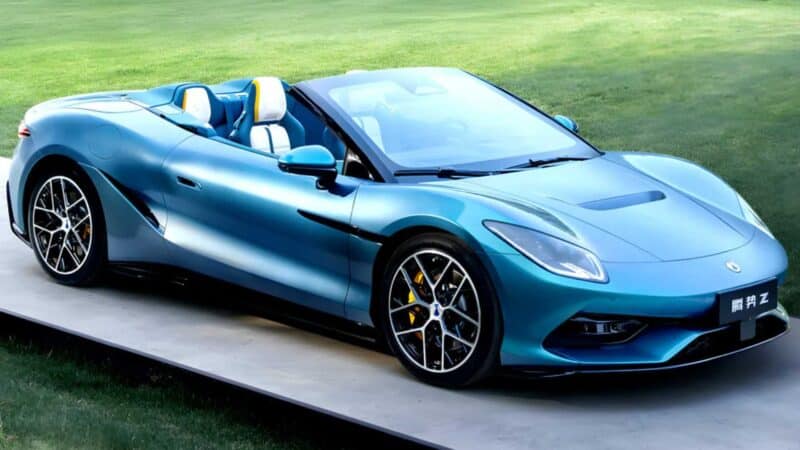 Carro esportivo conversível azul da Denza, com design aerodinâmico, rodas esportivas e interior de dois tons, estacionado sobre uma plataforma ao ar livre