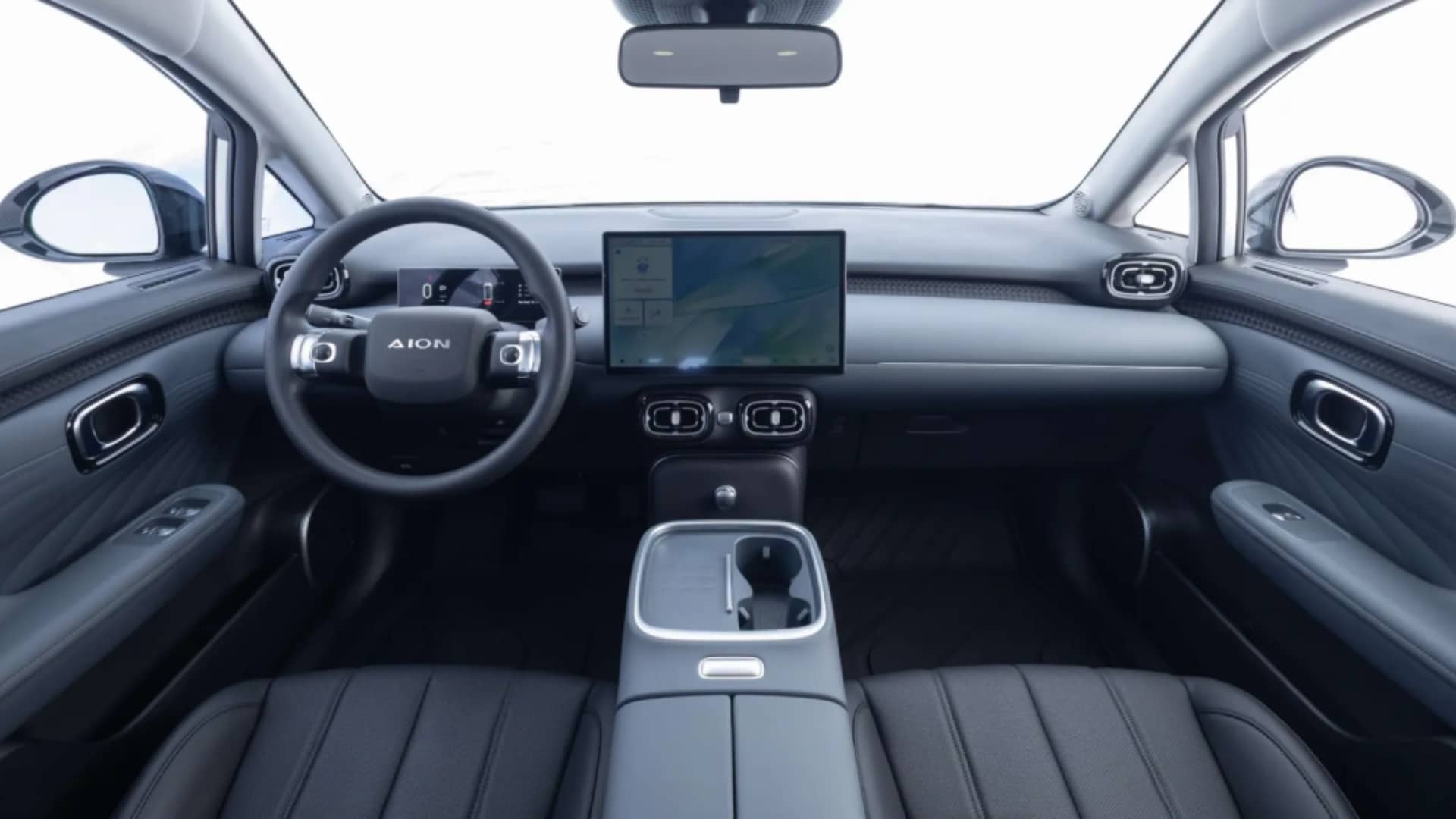 Imagem do interior do GAC Aion UT na cor cinza, mostrando a central multimídia de 14,6 polegadas, volante e bancos em tons de cinza