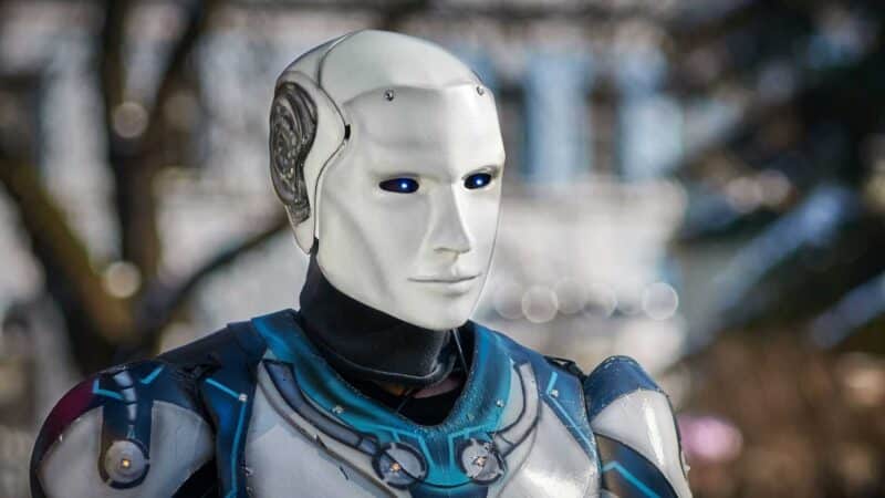 Robô humanoide com rosto branco e olhos azuis iluminados