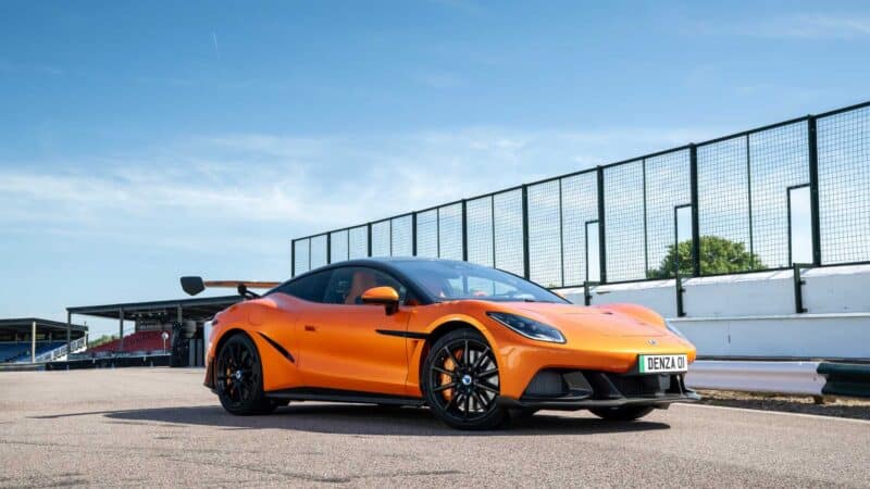 Denza Z Racing na cor laranja acelera em uma pista, exibindo aerofólio traseiro, linhas aerodinâmicas e visual esportivo