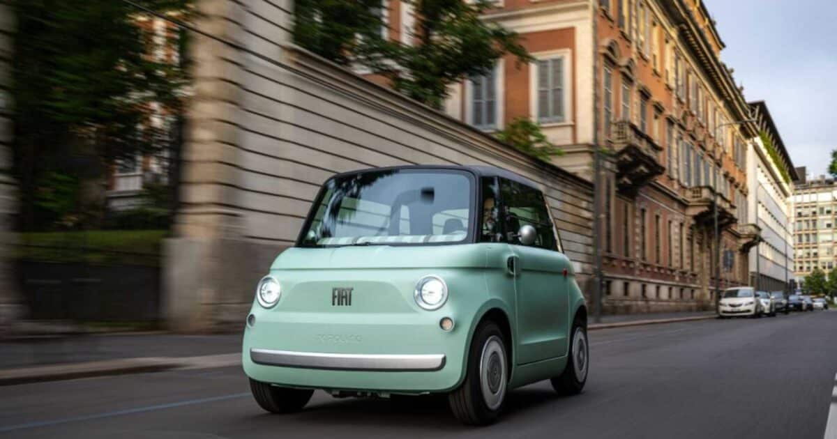 Fiat Topolino elétrico circula por uma rua em área urbana histórica