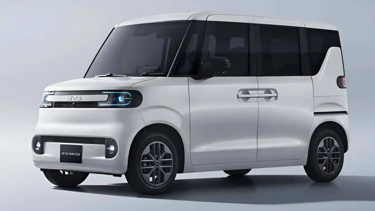 Frente e lateral esquerda de um BYD Racco branco. O design apresenta linhas verticais, vidros escuros, retrovisores pretos e uma assinatura luminosa frontal azul