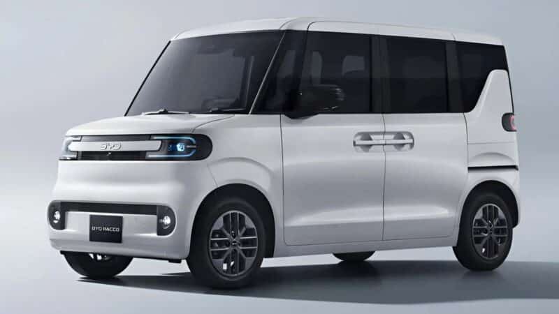 Frente e lateral esquerda de um BYD Racco branco. O design apresenta linhas verticais, vidros escuros, retrovisores pretos e uma assinatura luminosa frontal azul