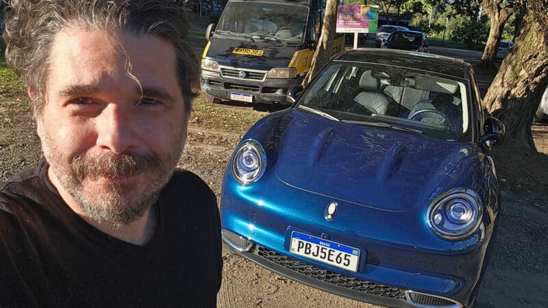 O jornalista Fábio Marton com o GWM Ora 03 ao fundo