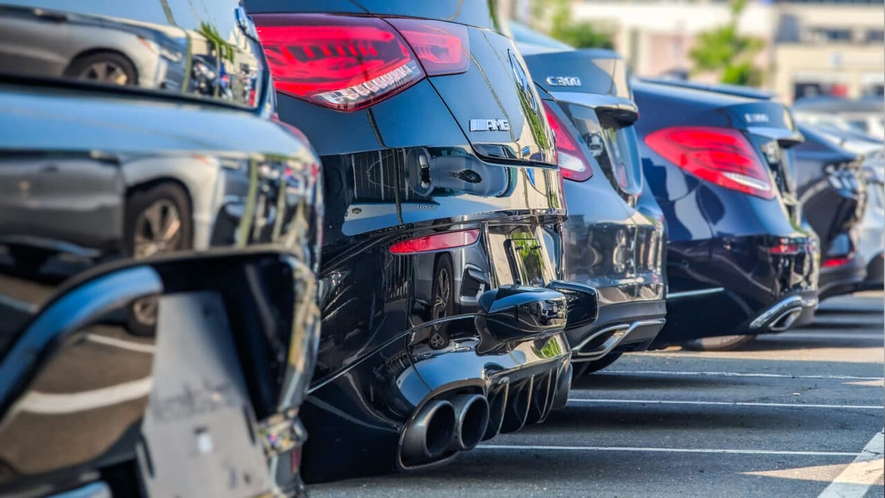 Detalhe de carros no pátio de uma locadora, mostrando escapamentos