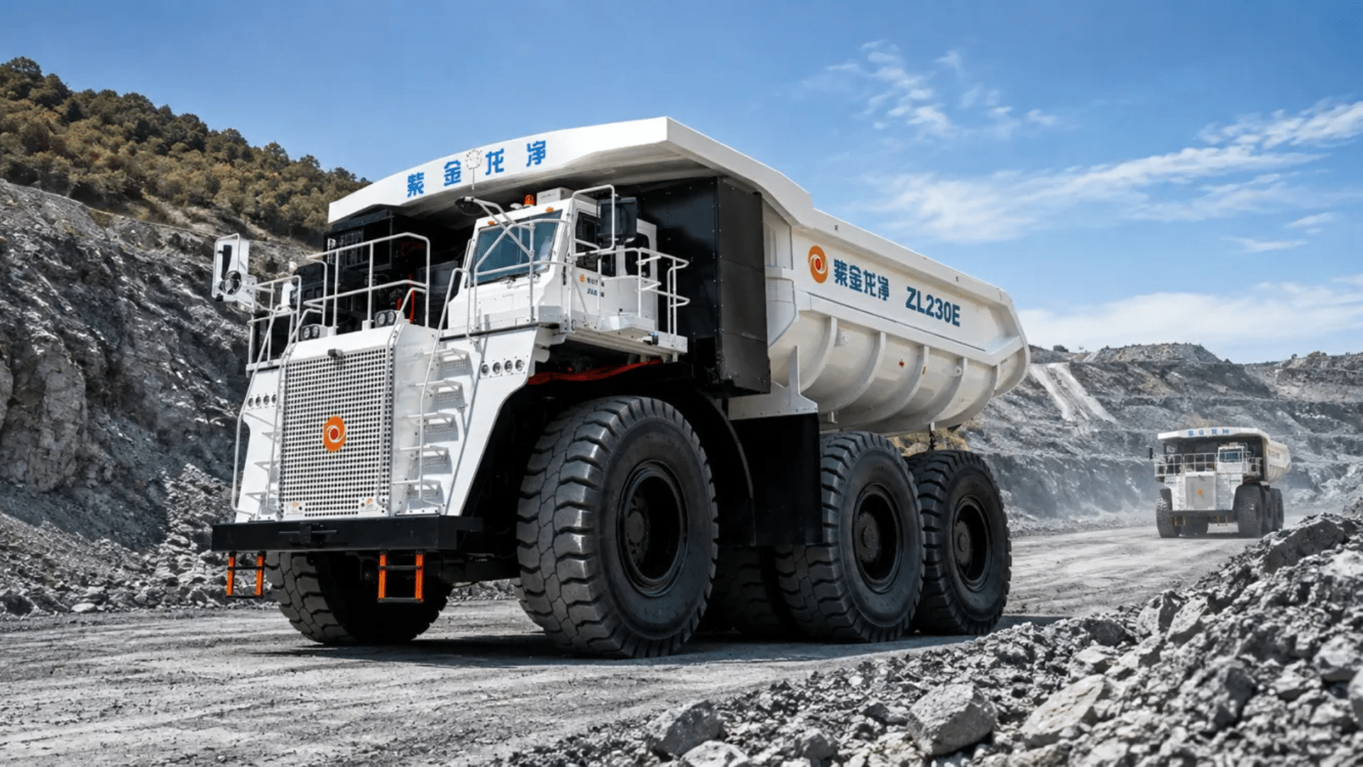 Caminhão de mineração gigante ZL230E com trabalhadores ao lado, em pátio industrial
