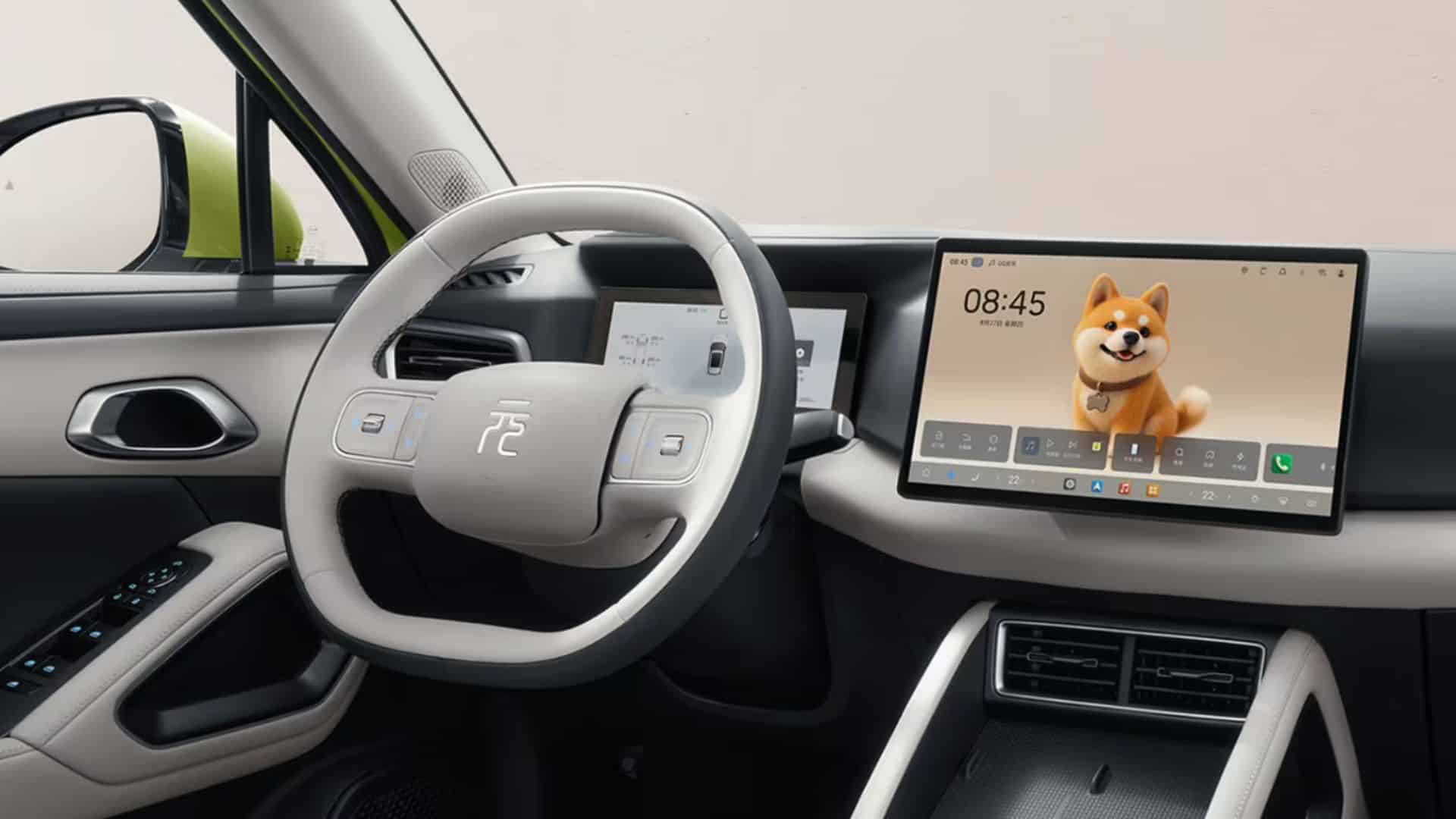 Interior do BYD Yuan Up 2027 em tons claros de bege e cinza, com volante de dois raios revestido em couro claro e o emblema "元" (Yuan) ao centro