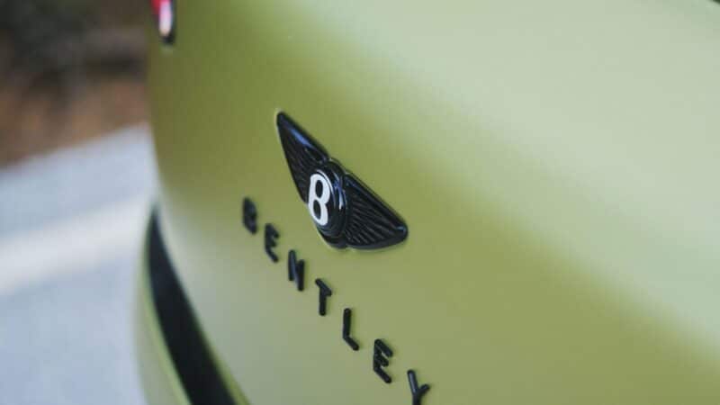 Marca Bentley em destaque na carroceria verde, com foco no logotipo alado