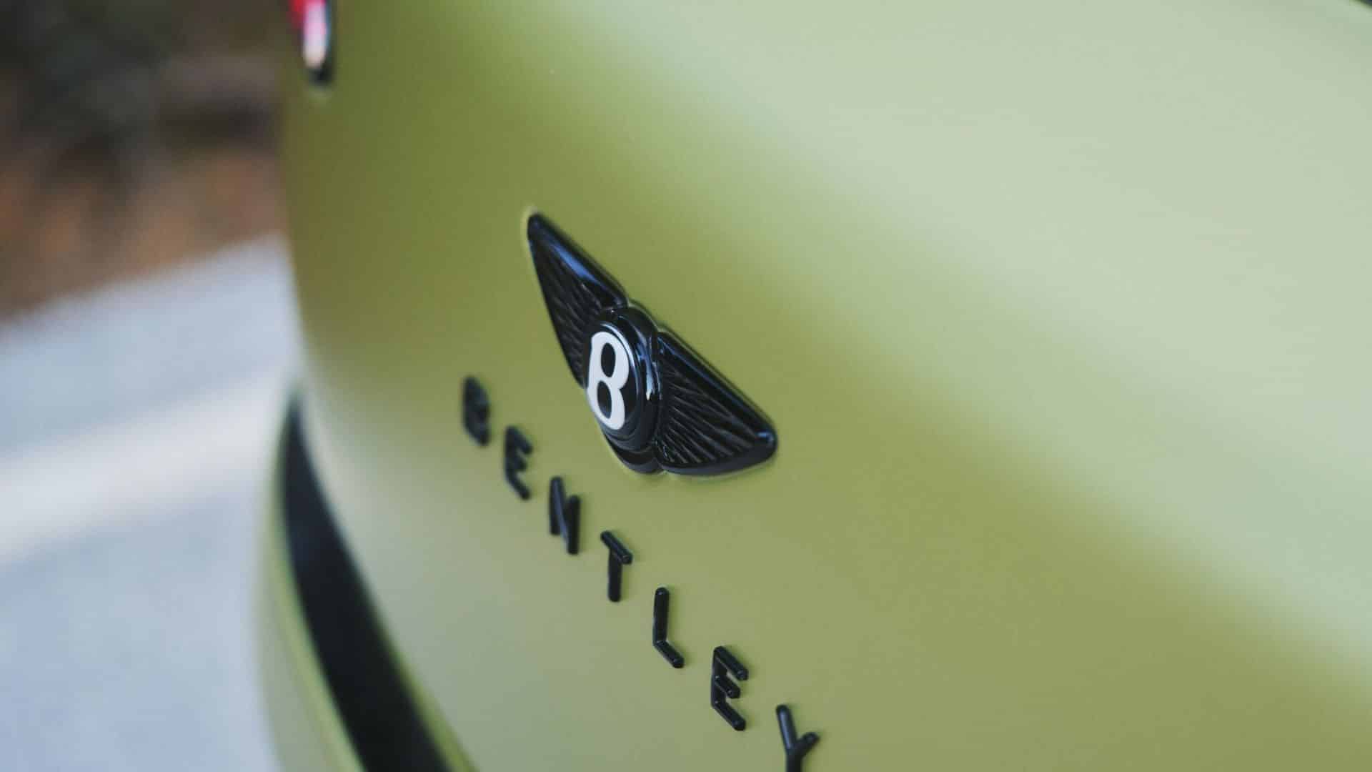 Marca Bentley em destaque na carroceria verde, com foco no logotipo alado