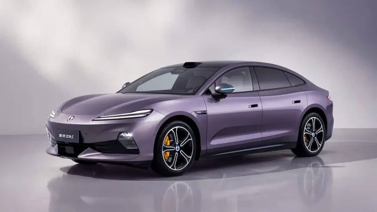 Denza Z9S 2026 na cor Roxo Matinal, visto em ângulo frontal três-quartos em fundo de estúdio cinza. O sedã elétrico exibe faróis divididos com assinatura em LED, painel frontal fechado, LiDAR montado no teto, retrovisores com indicadores em LED azul, rodas de liga leve de 20 polegadas com pinças de freio amarelas e silhueta aerodinâmica tipo cupê com teto preto contrastante