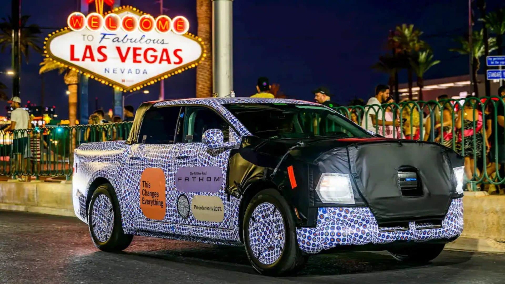 Imagem noturna de Las Vegas com o Ford Fathom estacionado em destaque sob um letreiro neon.