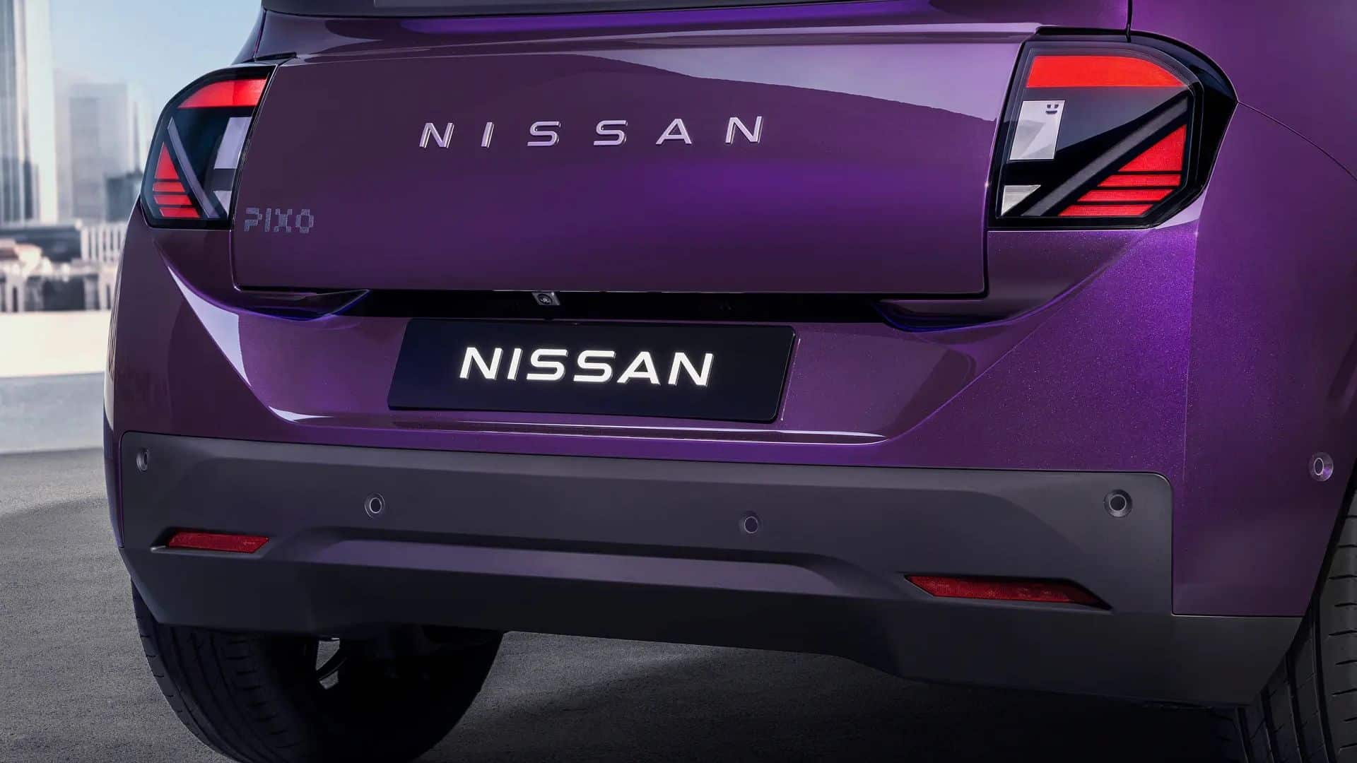 Vista traseira do Nissan PIXO na cor roxa, destacando o nome 'NISSAN' escrito na tampa do porta-malas, o logotipo 'PIXO' à esquerda e as lanternas traseiras com design angular e detalhes em vermelho e preto. O para-choque traseiro é cinza escuro com sensores de estacionamento
