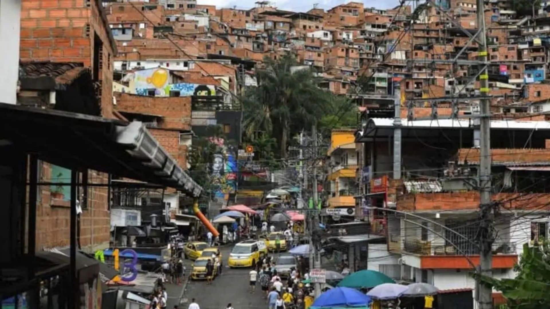 VW ID. Buzz na viagem recordista de Rainer Zietlow, em Medellín, Colômbia.
Vista de uma rua íngreme e movimentada em uma comunidade de encosta, com casas de tijolo aparente empilhadas na colina ao fundo