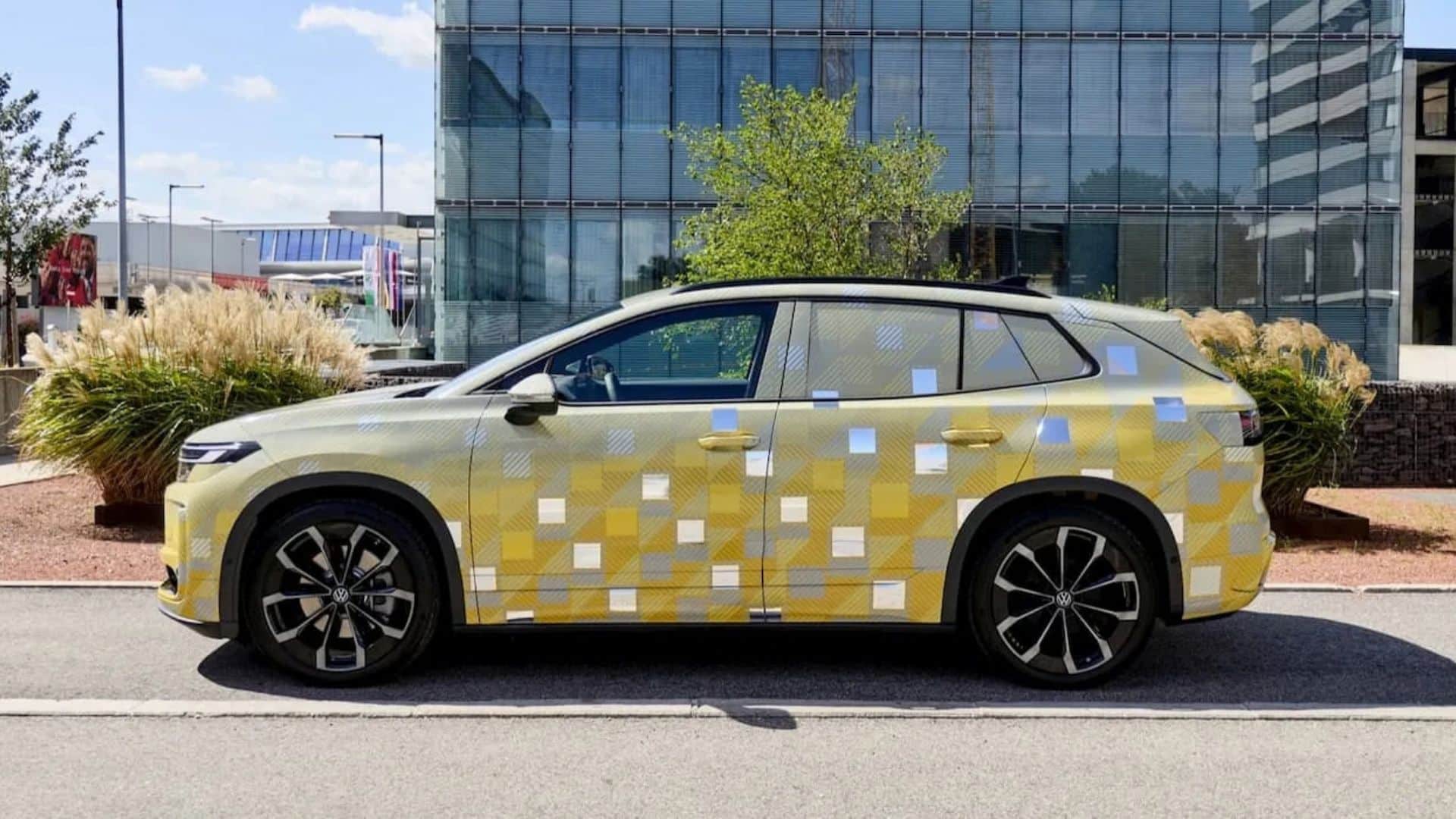 Protótipo camuflado do Volkswagen ID. Tiguan 2027 estacionado em uma via urbana, visto de perfil