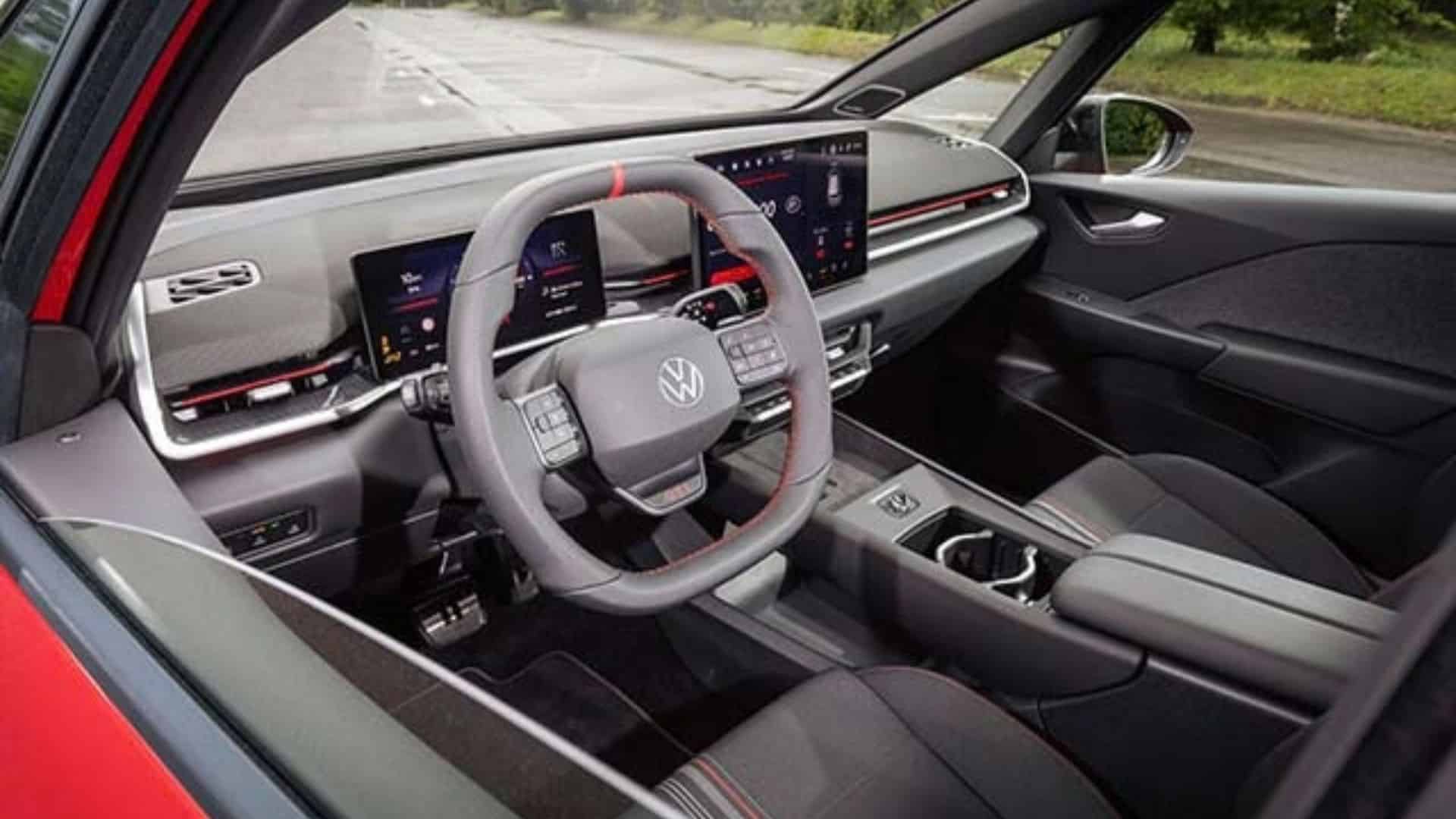 Painel do Volkswagen ID.3 GTI com volante esportivo de couro com detalhe vermelho às 12 horas e botão GTI iluminado, Digital Cockpit, tela de infoentretenimento Innovision de 12,9 polegadas e console central com controle rotativo