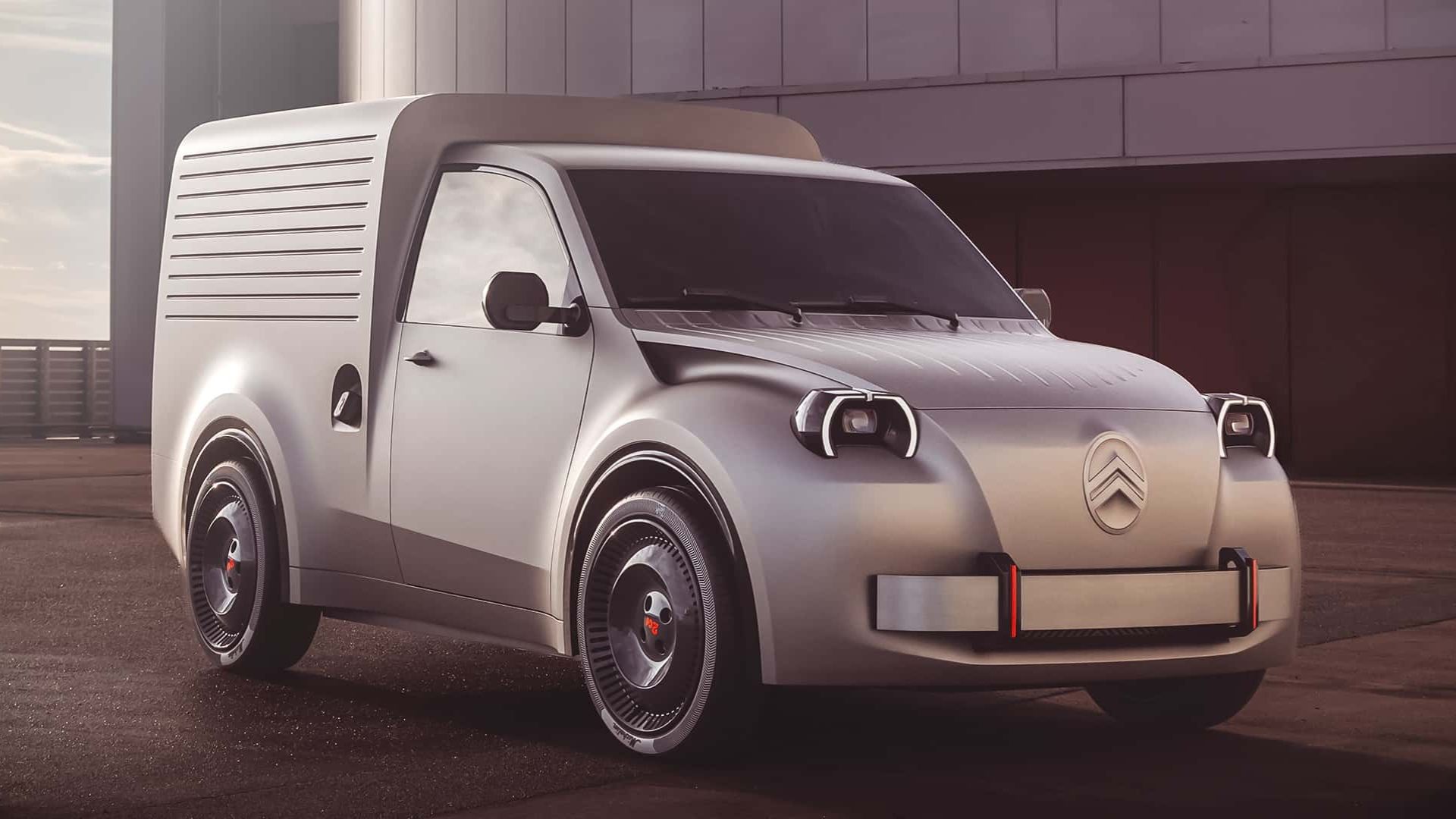 Citroën 2CV Fourgonette Concept, uma van elétrica compacta em tom prateado fosco, vista em ângulo frontal três-quartos. O veículo possui faróis redondos com molduras em preto e branco, para-choque dianteiro robusto com detalhes em vermelho e o logotipo da Citroën em destaque