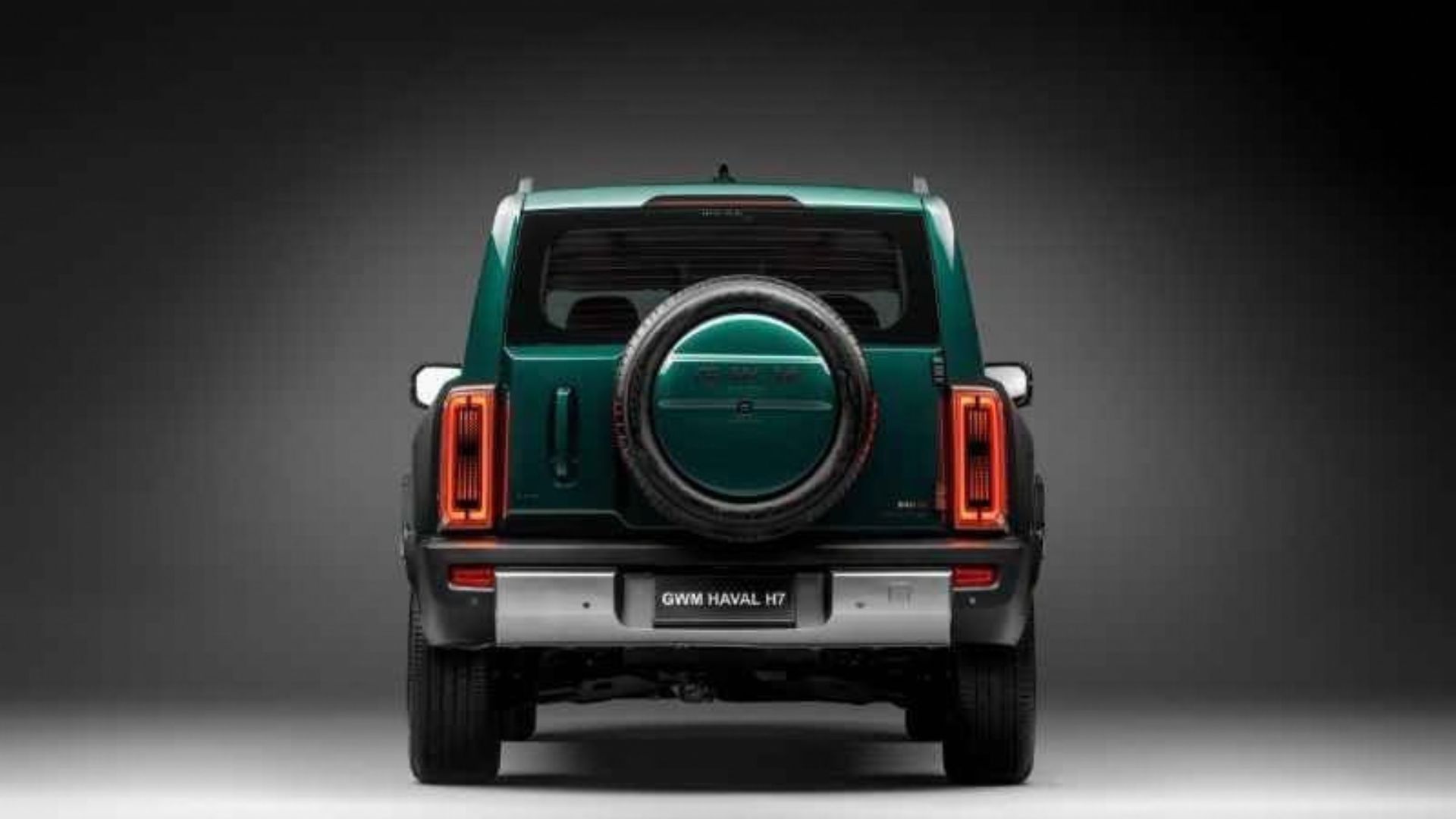Traseira do GWM Haval H7 na cor verde-escura, com destaque para a roda sobressalente montada na porta traseira, lanterias verticais de LED com formato retangular e para-choque inferior em cinza com detalhes prateados
