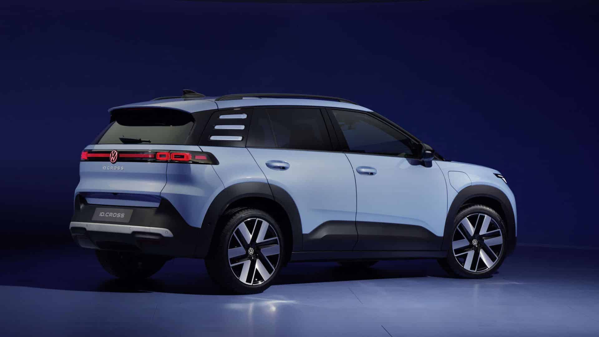 Volkswagen ID. Cross azul-claro visto de traseira em ângulo de três quartos contra fundo azul-escuro de estúdio, destacando a lanterna traseira em LED vermelha contínua, o logotipo VW iluminado e as rodas de liga leve com detalhes em preto e prata