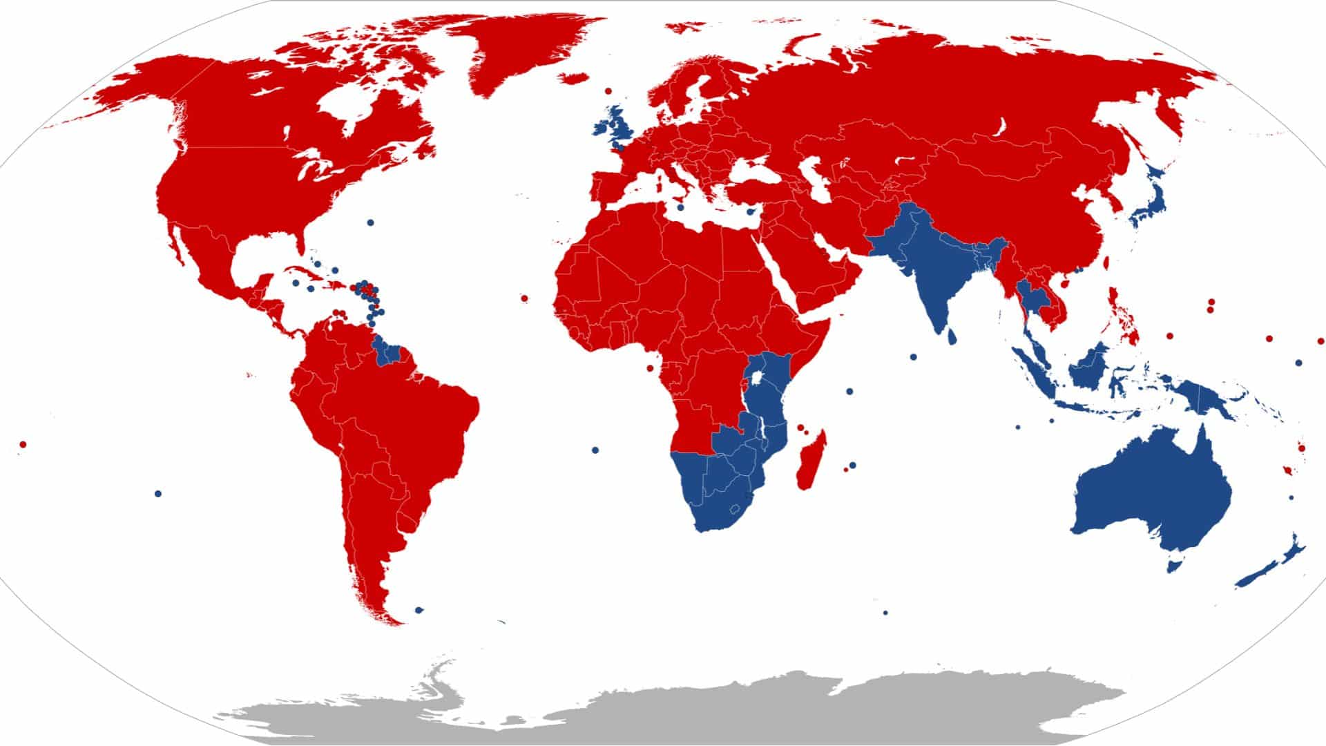 Mapa-múndi político dividido entre países com direção à esquerda e à direita. Os países pintados de vermelho, que representam aqueles com direção à direita (mão direita na estrada), incluem a maior parte das Américas, Europa continental, África, Oriente Médio, Rússia e China. Os países pintados de azul, que representam aqueles com direção à esquerda (mão esquerda na estrada), incluem o Reino Unido, Índia, Austrália, Nova Zelândia, Japão, Coreia do Sul, Sudeste Asiático, parte do sul da África (como África do Sul e Namíbia), Guiana e ilhas do Caribe