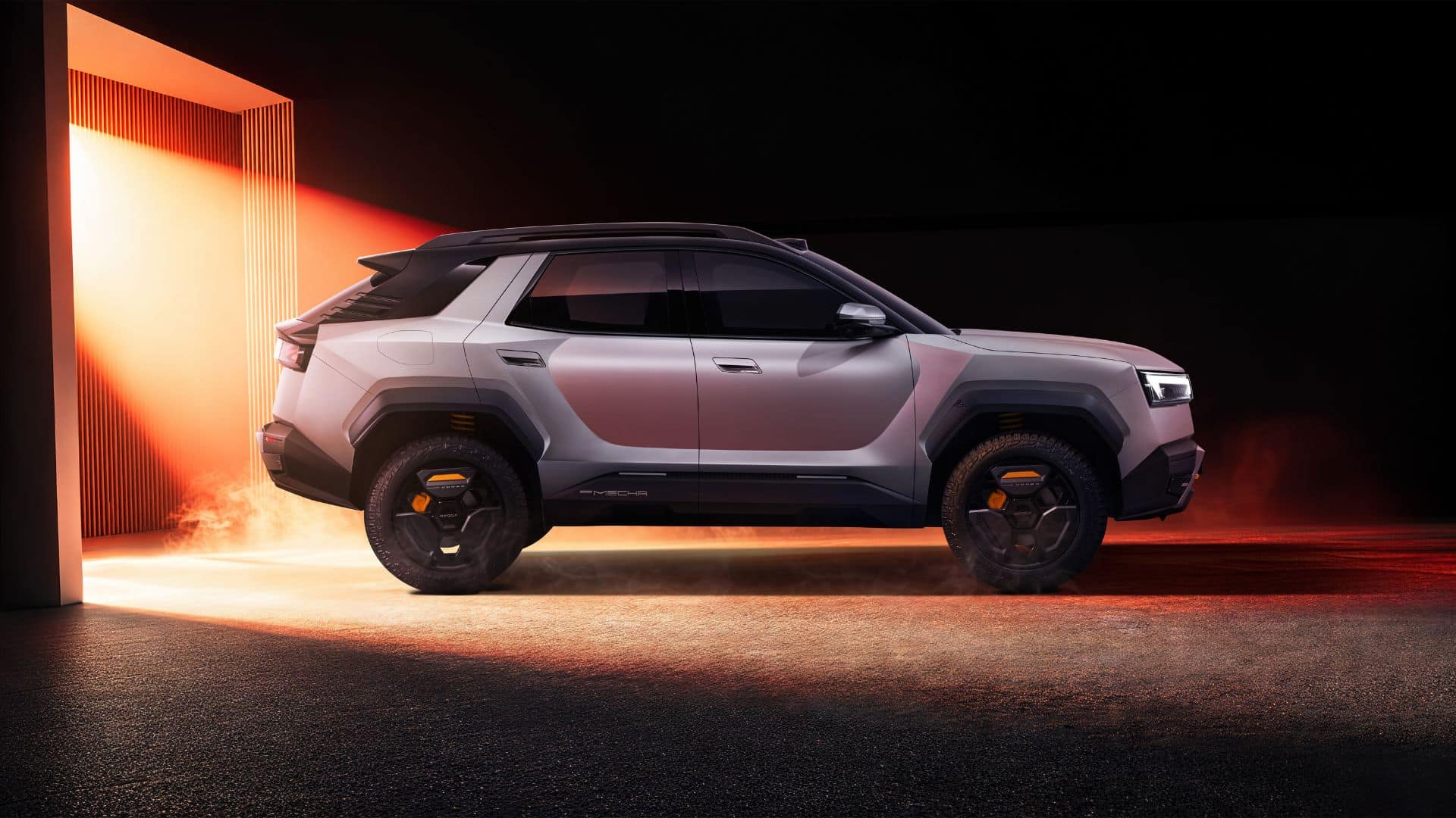 Vista lateral do OMODA X em um estúdio escuro, iluminado por uma forte luz laranja ao fundo. O crossover prata exibe caixas de roda pretas robustas, pneus de uso misto e detalhes em laranja nas rodas, reforçando o design aventureiro