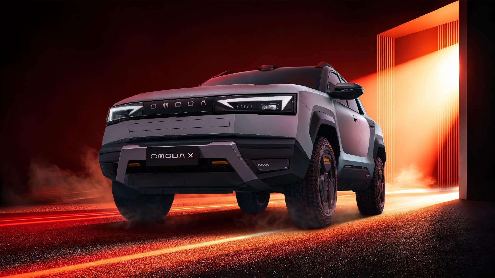 Vista frontal do OMODA X em ângulo baixo, com iluminação vermelha e laranja dramática. Destacam-se os faróis em LED em formato de 'T', a grade frontal fechada com a inscrição OMODA e o para-choque robusto com detalhes em laranja