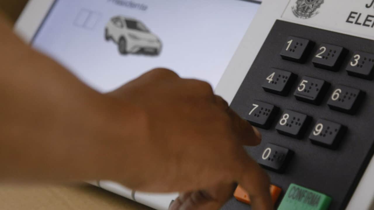Montagem com um carro elétrico aparecendo numa urna eletrônica