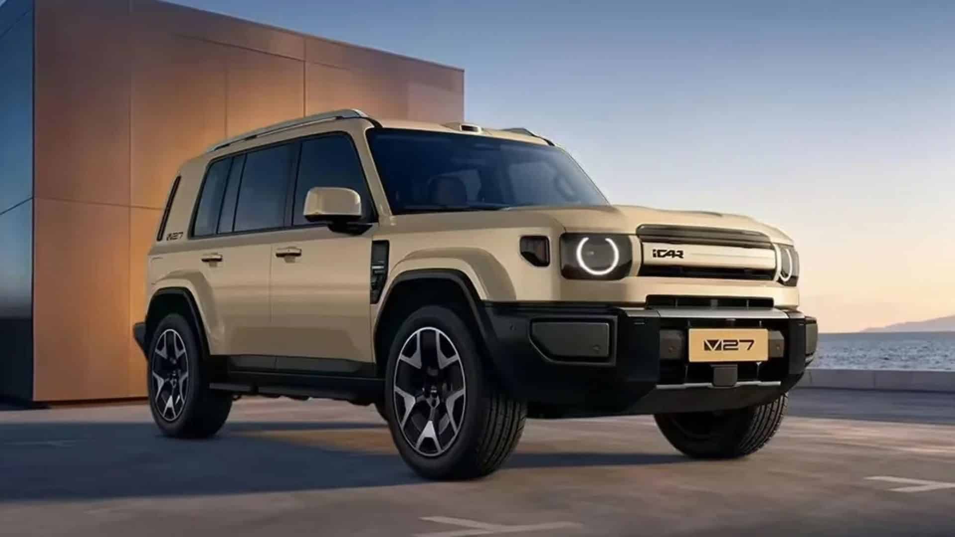 SUV iCar V27 bege visto de frente, estacionado em uma área externa ao lado de um prédio, com faróis redondos de LED e o logotipo iCAR na grade frontal