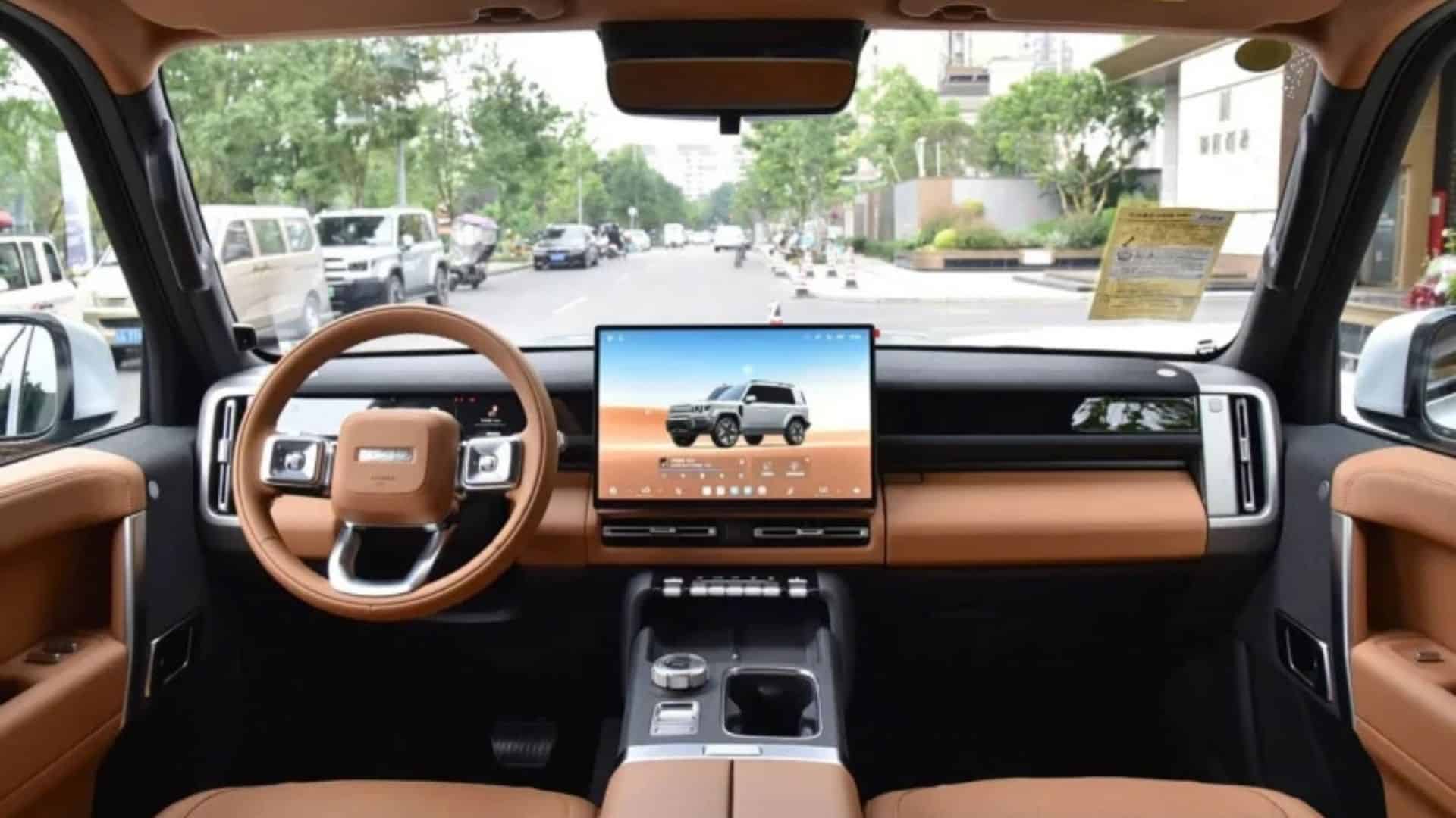 Painel interno do iCar V27, com volante de couro marrom, tela central grande exibindo a imagem do veículo, console central com controles e acabamento em couro marrom e preto