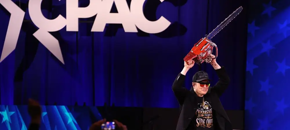 Elon Musk com uma motosserra no CPAC em 2025